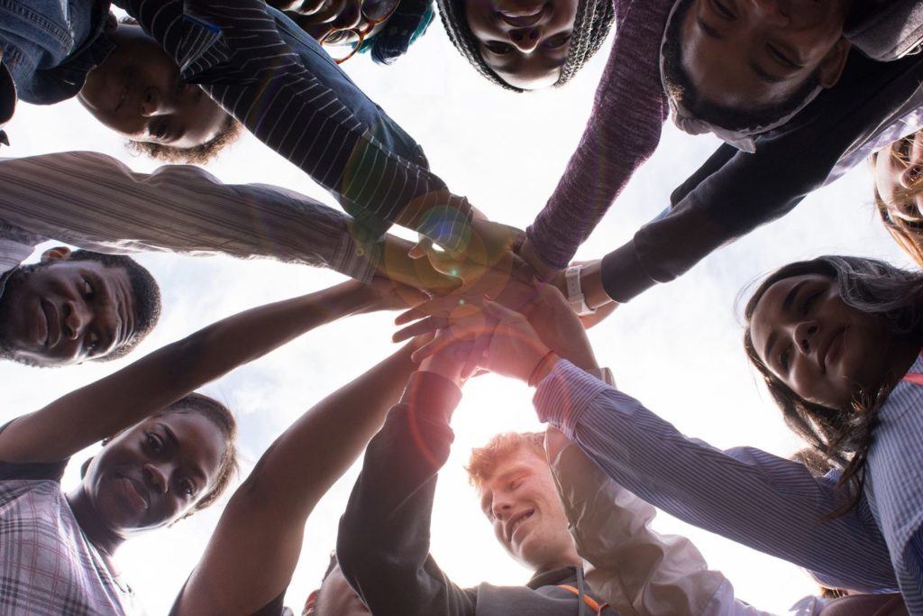 Bottom view of a team in a huddle with hands stacked together