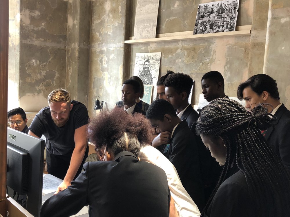 Picture of a teacher with students looking at a computer