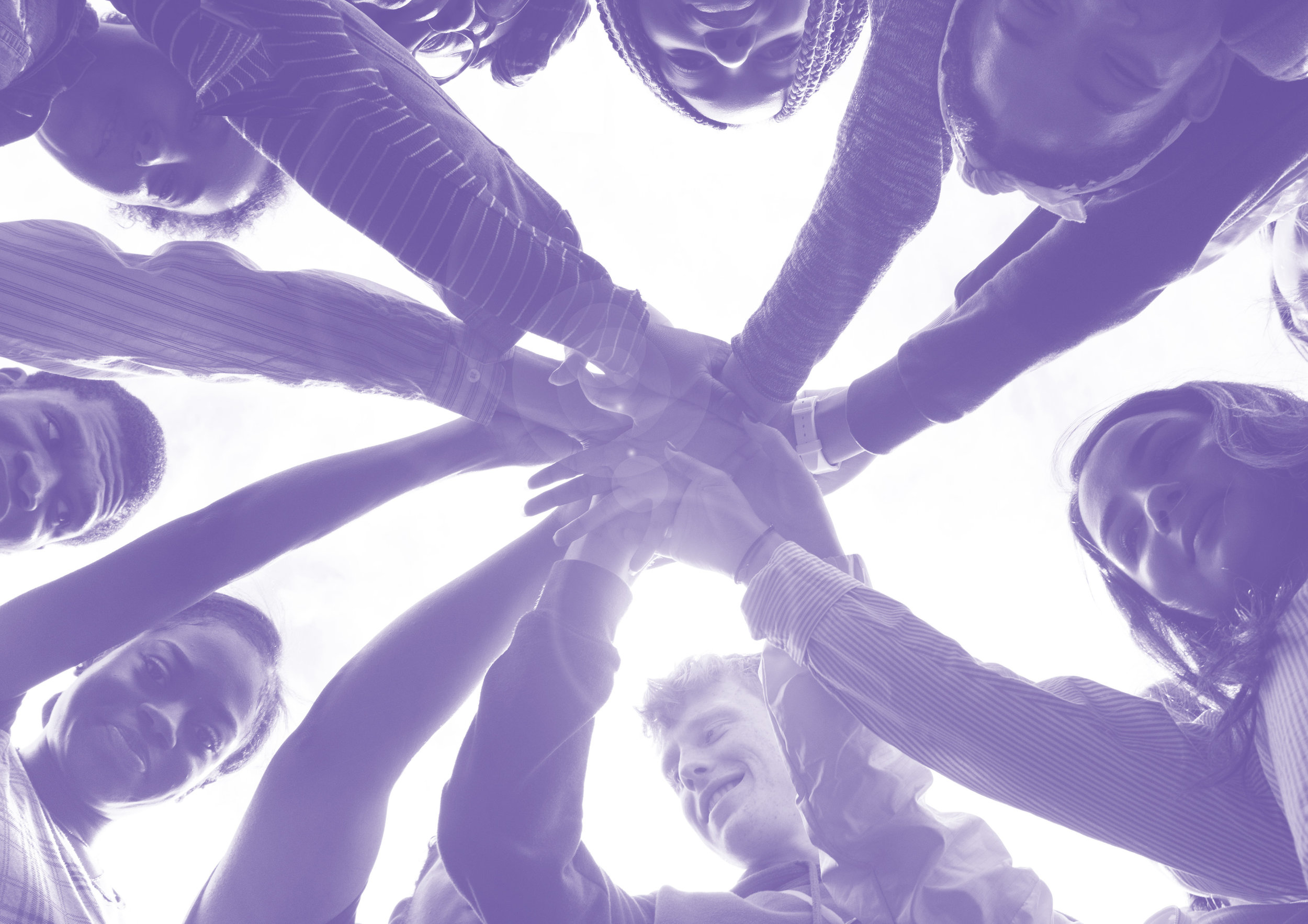 Bottom view of a team in a huddle with hands stacked together
